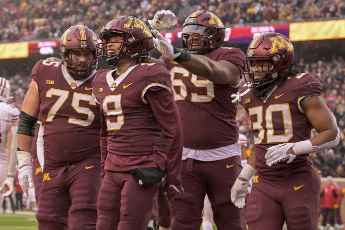 Minnesota Golden Gophers wide receiver Daniel Jackson (9) celebrates his 7-yard touchdown reception against the Wisconsin Badgers with offensive lineman Tyler Cooper (75), offensive lineman Aireontae Ersery (69), and running back Jordan Nubin (30) during the second quarter at Huntington Bank Stadium.
