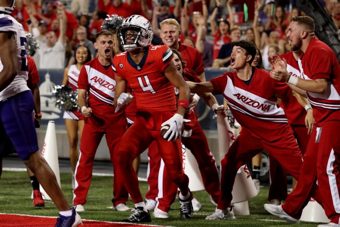 Arizona Wildcats wide receiver Tetairoa McMillan (4) celebrates a touchdown agaisnt the Washington Huskies with the cheer leaders in the second half at Arizona Stadium.