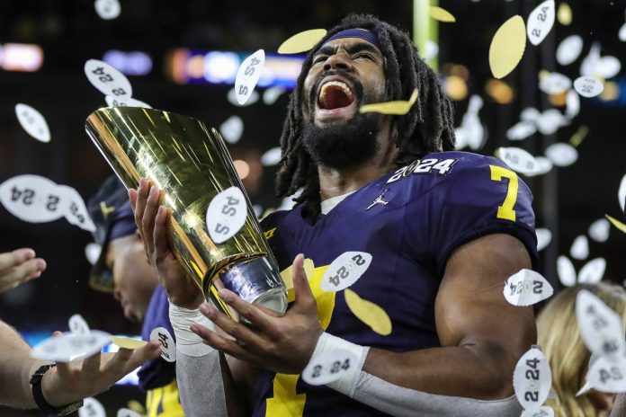 Michigan running back Donovan Edwards lifts the trophy to celebrate the 34-13 win over Washington in the national championship game at NRG Stadium.