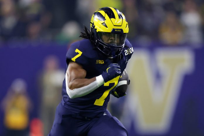 Michigan Wolverines running back Donovan Edwards (7) runs with the ball for a touchdown against the Washington Huskies during the first quarter in the 2024 College Football Playoff national championship game at NRG Stadium.