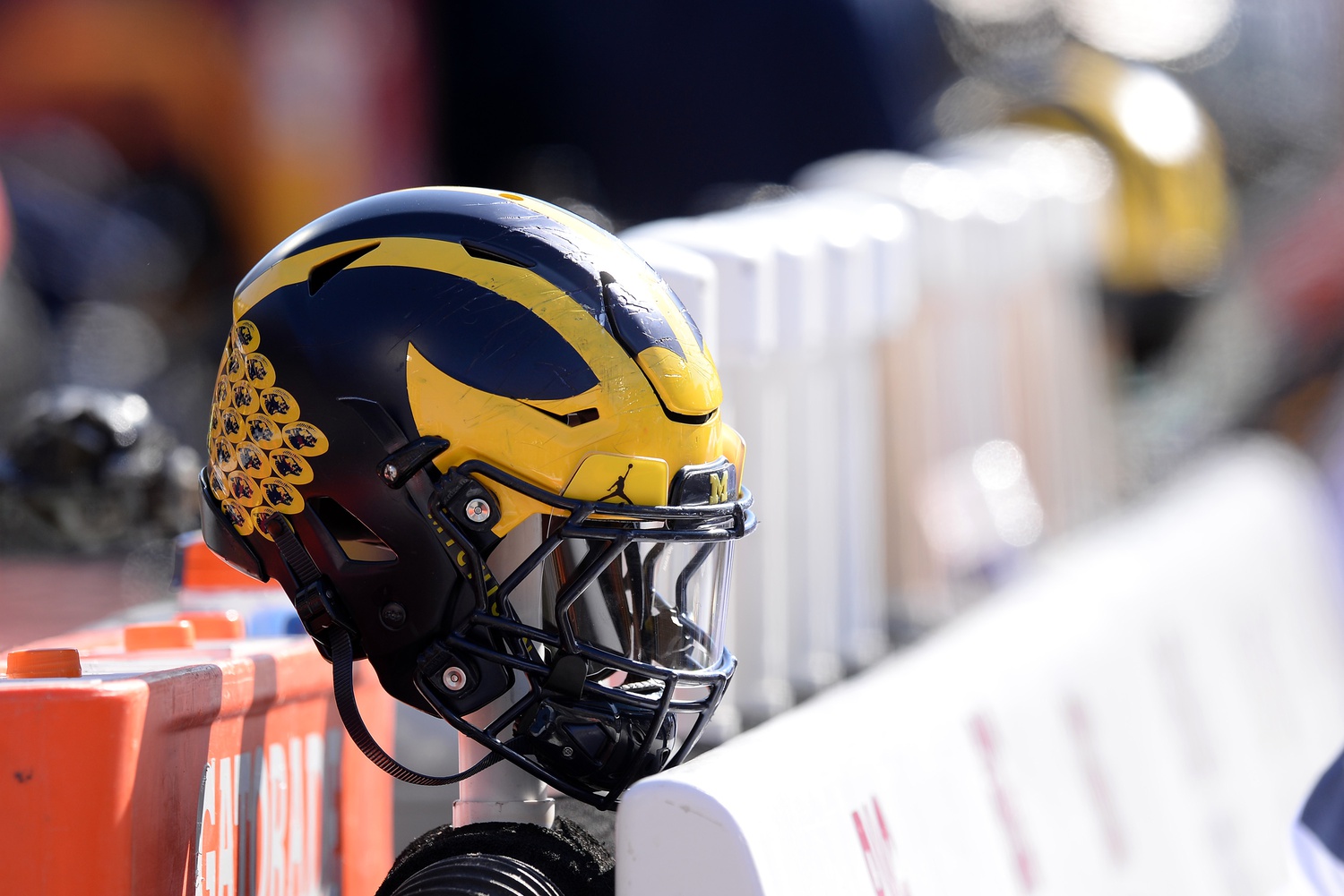 A Michigan Wolverines helmet sits on the back of the bench during the second half of the game against the Illinois Fighting Illini at Memorial Stadium.