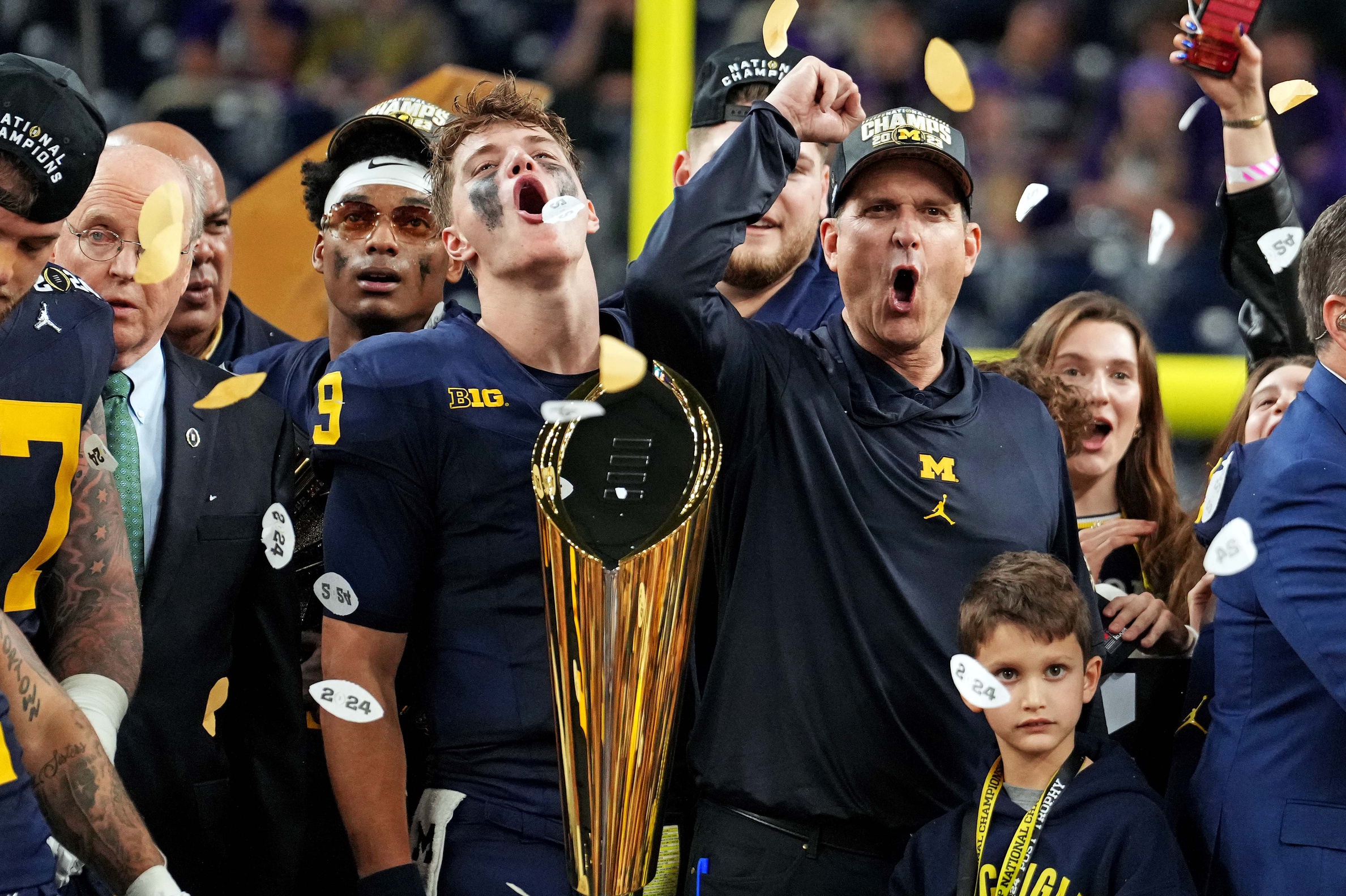 Michigan Wolverines wide receiver Cornelius Johnson (6) and head coach Jim Harbaugh celebrate after beating the Washington Huskies in the 2024 College Football Playoff national championship game at NRG Stadium.