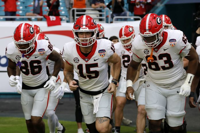 Georgia Bulldogs quarterback Carson Beck (15) leads the team onto the field before the game against the Florida State Seminoles for the 2023 Orange Bowl at Hard Rock Stadium.