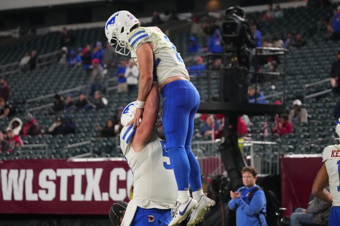 SMU Mustangs wide receiver Moochie Dixon (5) lifts SMU Mustangs quarterback Preston Stone (2) to celebrate his touchdown against the Temple Owls during the second half at Lincoln Financial Field.