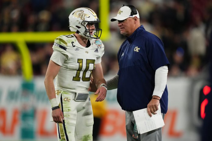 Georgia Tech Yellow Jackets quarterback Haynes King (10) talks with head coach Brent Key during the second half of the Gasparilla Bowl against the UCF Knights at Raymond James Stadium.