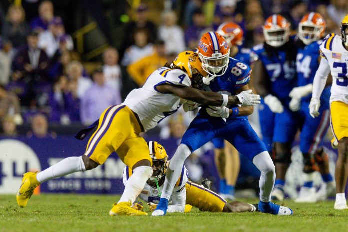 LSU Tigers linebacker Harold Perkins Jr. (4) tackles Florida Gators wide receiver Marcus Burke (88) during the second half at Tiger Stadium.