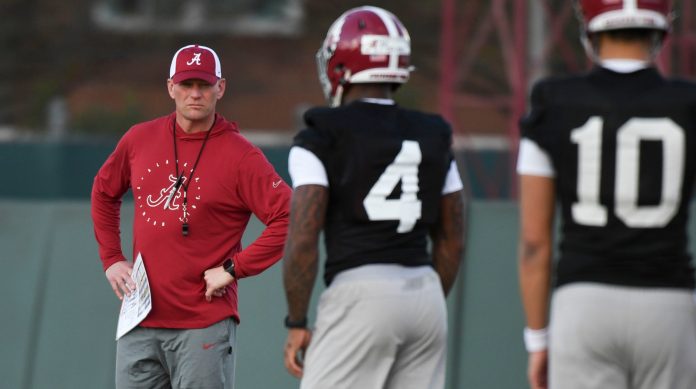 Alabama head coach Kalen DeBoer watches his quarterbacks, including Jalen Milroe, during practice.