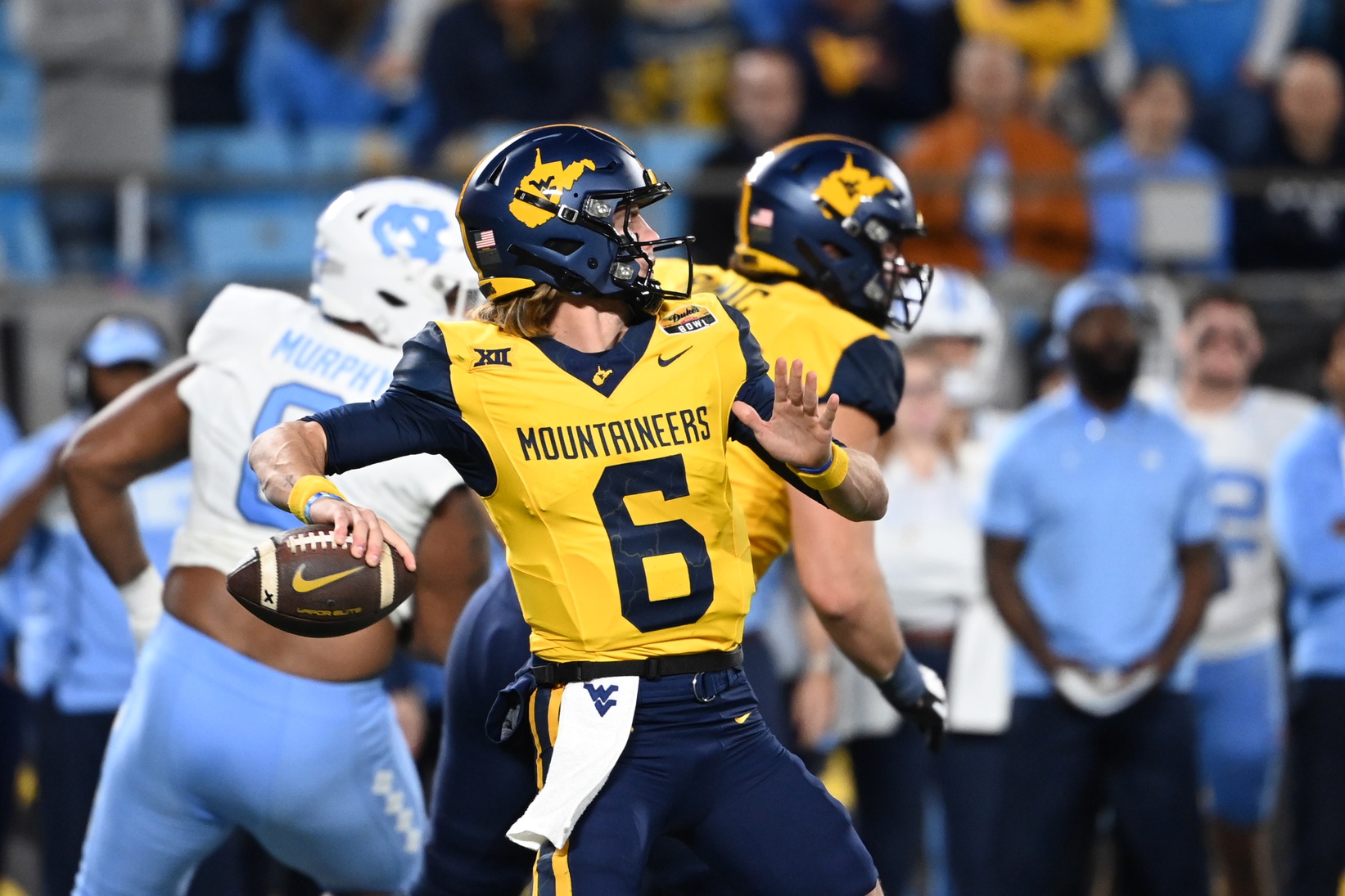 West Virginia Mountaineers quarterback Garrett Greene (6) throws a touchdown pass on the first play of the game in the first half at Bank of America Stadium. Mandatory Credit: Bob Donnan-USA TODAY Sports