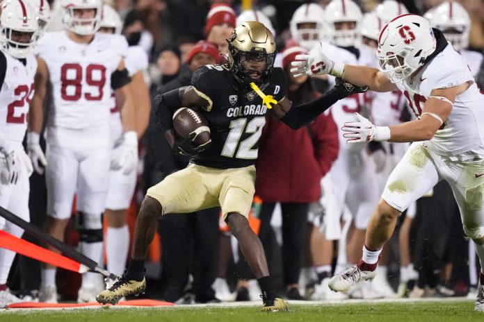 Colorado Buffaloes cornerback Travis Hunter (12) carries the ball away from Stanford Cardinal linebacker Spencer Jorgensen (10) in the second quarter at Folsom Field.