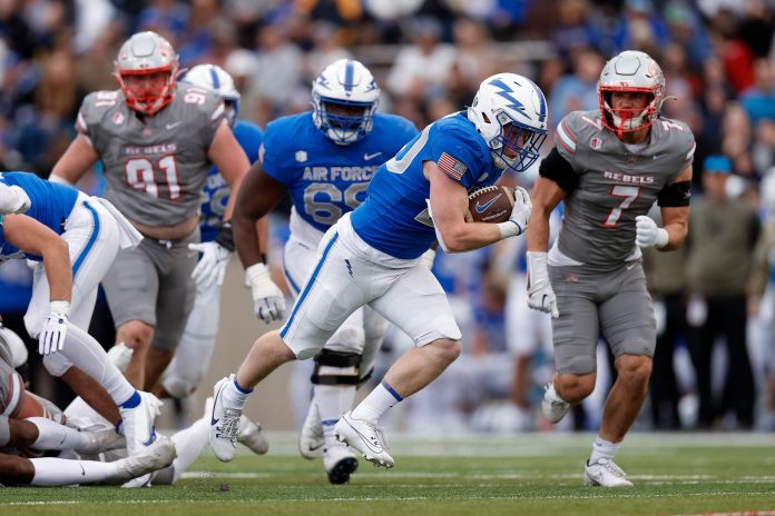 Air Force Falcons running back Dylan Carson (20) runs the ball ahead of guard Wesley Ndago (69) and UNLV Rebels linebacker Jackson Woodard (7) in the first quarter at Falcon Stadium. Mandatory Credit: Isaiah J. Downing-USA TODAY Sports