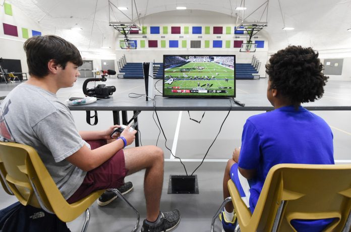 Two players play the latest EA Sports College Football 25 video game.