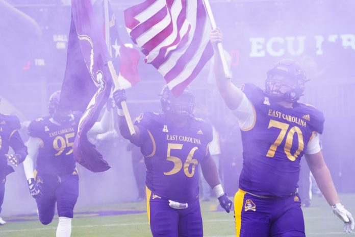 Nov 6, 2021; Greenville, North Carolina, USA; East Carolina Pirates offensive lineman Grant Copeland (70) and defensive lineman D'Anta Johnson (56) come out onto the field carrying flags before a game against the Temple Owls at Dowdy-Ficklen Stadium. Mandatory Credit: James Guillory-USA TODAY Sports