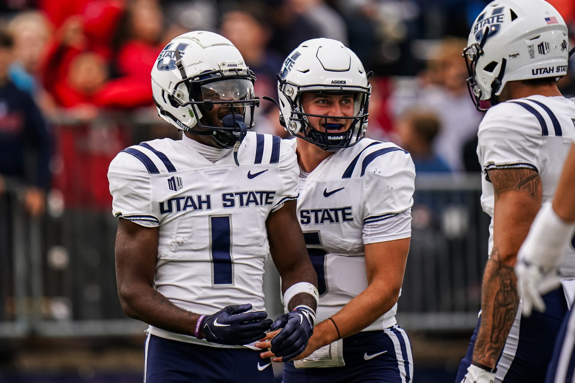 Utah State Aggies wide receiver Jalen Royals (1) is congratulated by quarterback Cooper Legas (5) after running the ball for a touchdown against the UConn Huskies in the second half at Rentschler Field at Pratt & Whitney Stadium. Mandatory Credit: David Butler II-USA TODAY Sports