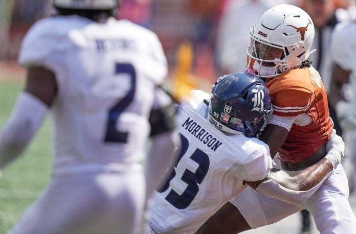 Texas Longhorns wide receiver Xavier Worthy (1) fights for yardage against Rice Owls linebacker Myron Morrison (33) as he does out of bounds in the second half of an NCAA college football game, Saturday, Sept. 2, 2023, in Austin, Texas.