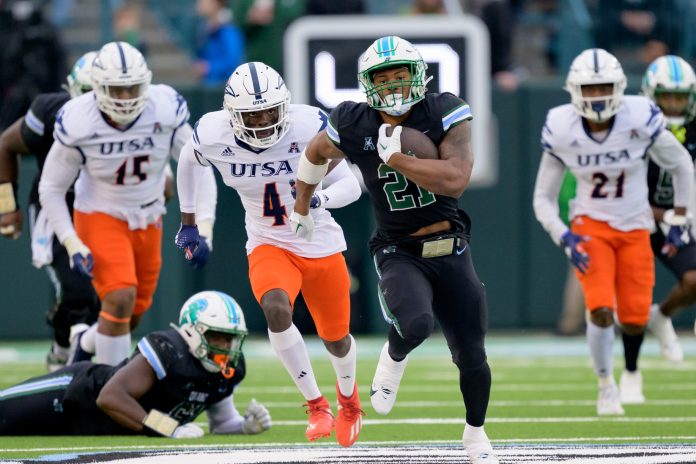 Nov 24, 2023; New Orleans, Louisiana, USA; Tulane Green Wave running back Makhi Hughes (21) runs against UTSA Roadrunners running back Kevorian Barnes (4) during the first half at Yulman Stadium. Mandatory Credit: Matthew Hinton-USA TODAY Sports