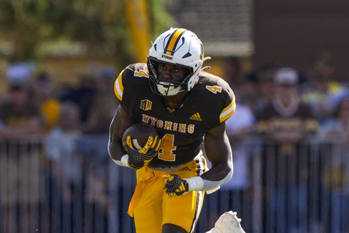 Wyoming Cowboys running back Harrison Waylee (4) runs against the New Mexico Lobos during the first quarter at Jonah Field at War Memorial Stadium. Mandatory Credit: Troy Babbitt-USA TODAY Sports