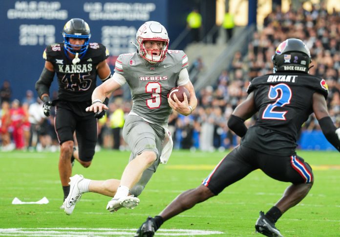 UNLV Rebels quarterback Matthew Sluka (3) runs the ball against Kansas Jayhawks defensive end Dean Miller (45) and cornerback Cobee Bryant (2) during the first half at Children's Mercy Park.