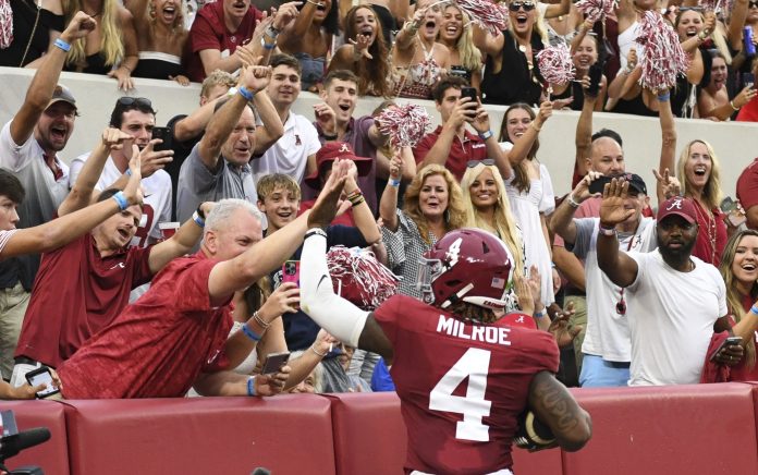 Alabama Crimson Tide quarterback Jalen Milroe (4) celebrates with fans after scoring against the Western Kentucky Hilltoppers during the first half at Bryant-Denny Stadium.