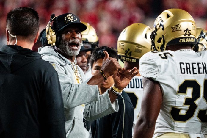 Colorado Buffaloes head coach Deion Sanders talks with players during a timeout in the third quarter against the Nebraska Cornhuskers at Memorial Stadium.