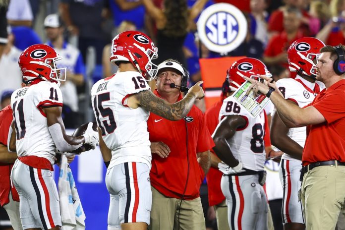 Georgia Bulldogs head coach Kirby Smart talks to quarterback Carson Beck (15) on the sidelines during the first quarter against the Kentucky Wildcats at Kroger Field.