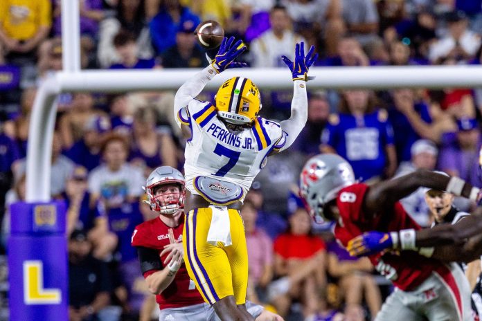 Nicholls State Colonels quarterback Pat McQuaide (7) rolls out of the pocket against LSU Tigers linebacker Harold Perkins Jr. (7) during the second half at Tiger Stadium.