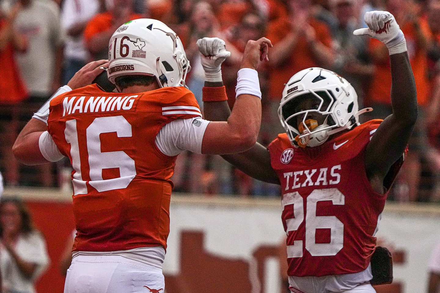 Texas Longhorns quarterback Arch Manning (16) and running back Quintrevion Wisner (26) celebrate a touchdown by Manning during the game against UTSA at Darrell K Royal-Texas Memorial Stadium.