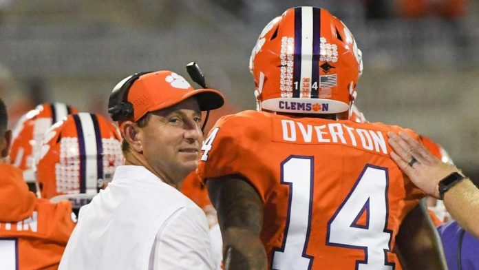 Clemson Head Coach Dabo Swinney looks back after greeting wide receiver Diondre Overton (14) following his third touchdown catch during the fourth quarter at Memorial Stadium before the game with Boston College in Clemson, South Carolina Saturday, October 26, 2019. Clemson Pregame Bc