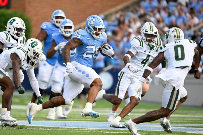 North Carolina Tar Heels running back Omarion Hampton (28) with the ball as Charlotte 49ers defensive backs C.J. Burton (4) and Al-Ma'hi Ali (0) defend in the 1st quarter at Kenan Memorial Stadium. Mandatory Credit: Bob Donnan-Imagn Images