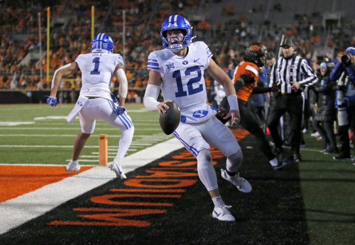 BYU's Jake Retzlaff (12) celebrates after scoring a touchdown in the first over time against the Oklahoma State University Cowboys at Boone Pickens Stadium.