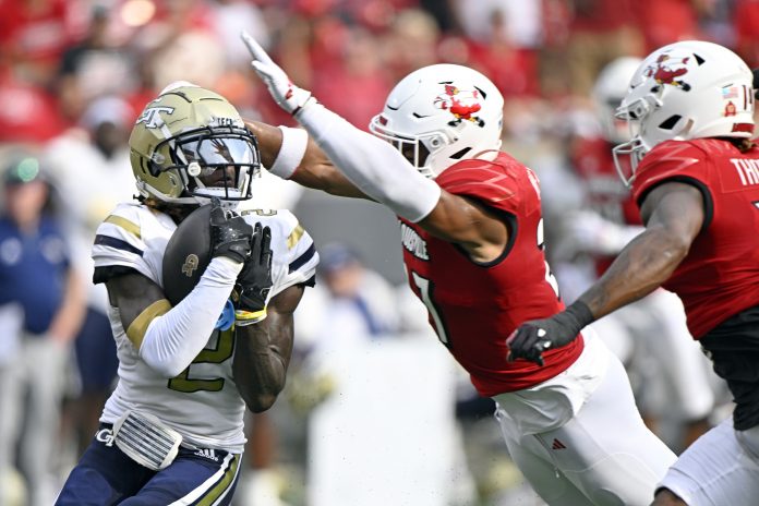 Georgia Tech Yellow Jackets wide receiver Eric Singleton Jr. (2) catches a pass under the pressure of Louisville Cardinals defensive back Devin Neal (27) during the first half at L&N Federal Credit Union Stadium.