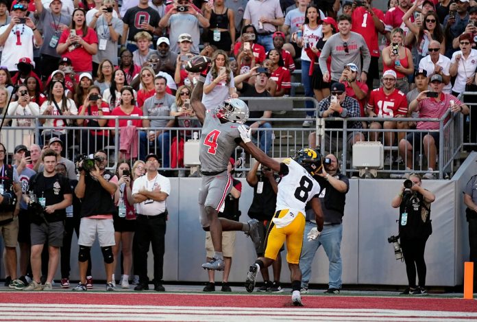 Ohio State Buckeyes wide receiver Jeremiah Smith (4) makes a touchdown grab against Iowa Hawkeyes defensive back Deshaun Lee (8) in the third quarter during the NCAA football game at Ohio Stadium.