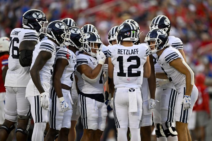 Brigham Young Cougars quarterback Jake Retzlaff (12) huddles with his team during the game between the Southern Methodist Mustangs and the Brigham Young Cougars at Gerald J. Ford Stadium.