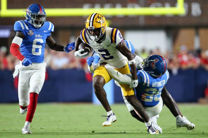 Sep 30, 2023; Oxford, Mississippi, USA; LSU Tigers wide receiver Kyren Lacy (2) runs after a catch as Mississippi Rebels defensive back Trey Washington (25) attempts to make the tackle during the second half at Vaught-Hemingway Stadium. Mandatory Credit: Petre Thomas-USA TODAY Sports