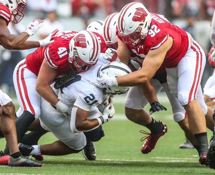 Wisconsin Badgers football's Noah Burks (41) and Matt Henningsen (92) tackle Penn Stateâ€™s Noah Cain (21) during their game Saturday, September 4, 2021 in Madison, Wis. Penn State won the game 16-10.