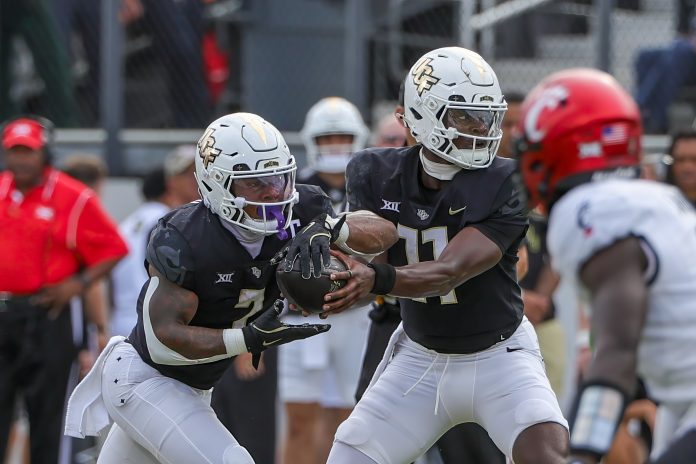 UCF Knights quarterback Jacurri Brown (11) hands off to running back RJ Harvey (7) during the first quarter against the Cincinnati Bearcats at FBC Mortgage Stadium.