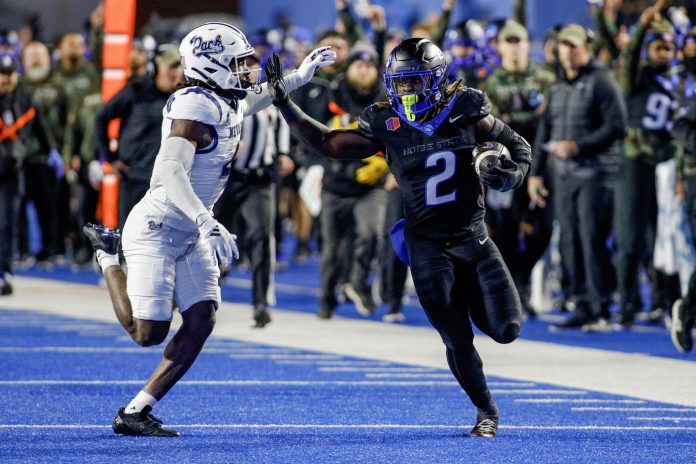 Boise State Broncos running back Ashton Jeanty (2) runs the ball against Nevada Wolf Pack safety Kitan Crawford (4) during the first quarter at Albertsons Stadium.