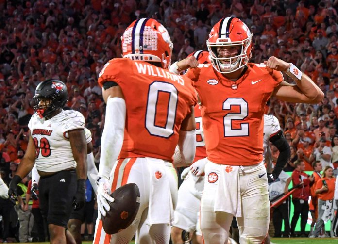 Clemson Tigers quarterback Cade Klubnik (2) celebrates after throwing a touchdown pass to wide receiver Antonio Williams (0) against the Louisville Cardinals during the first quarter at Memorial Stadium.