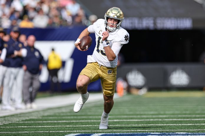 Notre Dame Fighting Irish quarterback Riley Leonard (13) carries the ball during the first half against the Navy Midshipmen at MetLife Stadium.