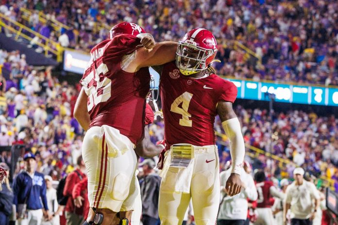 Alabama Crimson Tide quarterback Jalen Milroe (4) celebrates a touchdown with offensive lineman Geno VanDeMark (56) against the LSU Tigers during the second half at Tiger Stadium.