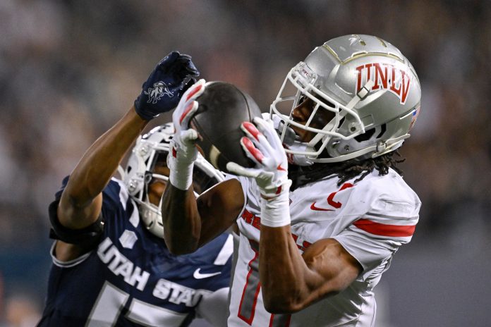 UNLV Rebels wide receiver Ricky White III (11) catches a touchdown pass in front of Utah State Aggies cornerback Avante Dickerson (17) in the first half at Merlin Olsen Field at Maverik Stadium.