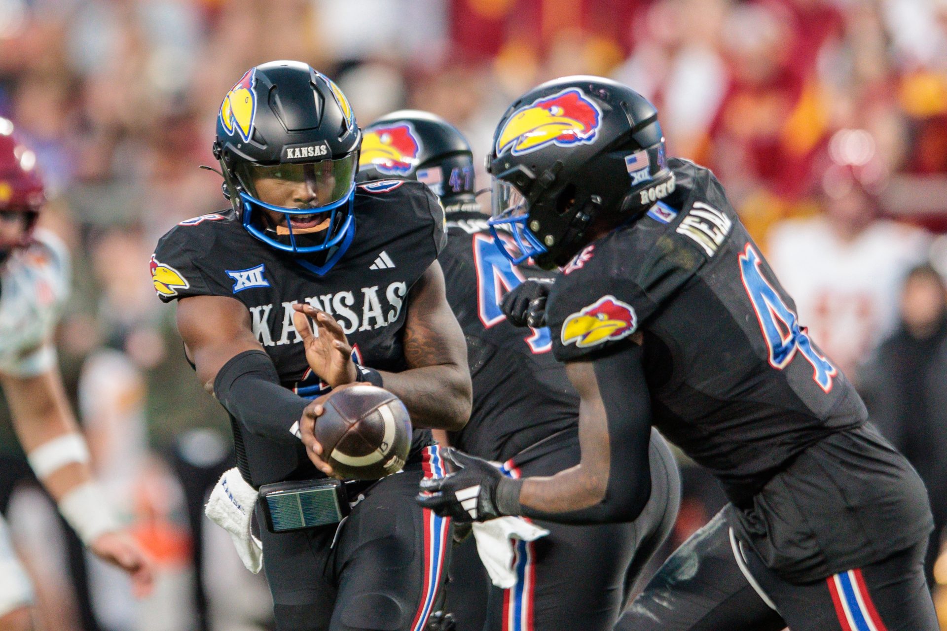 Kansas Jayhawks quarterback Jalon Daniels (6) hands off to Kansas Jayhawks running back Devin Neal (4) during the third quarter against the Iowa State Cyclones at GEHA Field at Arrowhead Stadium.