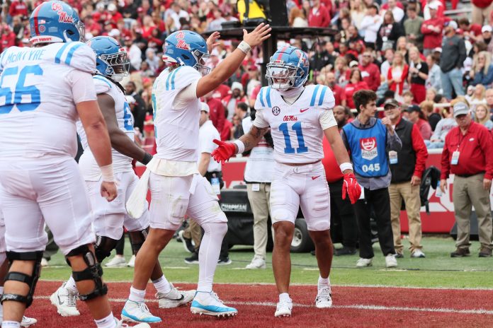 Ole Miss Rebels wide receiver Jordan Watkins (11) celebrates with quarterback Jaxson Dart (2) after catching a pass for a touchdown in the second quarter against the Arkansas Razorbacks at Donald W. Reynolds Razorback Stadium.