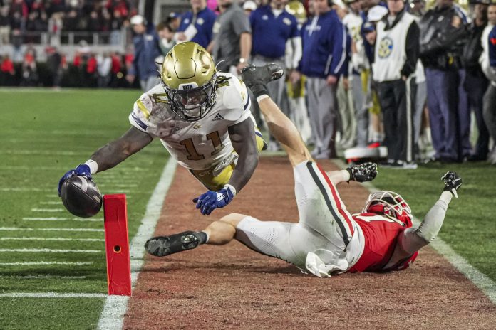 Georgia Tech Yellow Jackets running back Jamal Haynes (11) scores a touchdown past Georgia Bulldogs defensive back Dan Jackson (17) during the first half at Sanford Stadium.