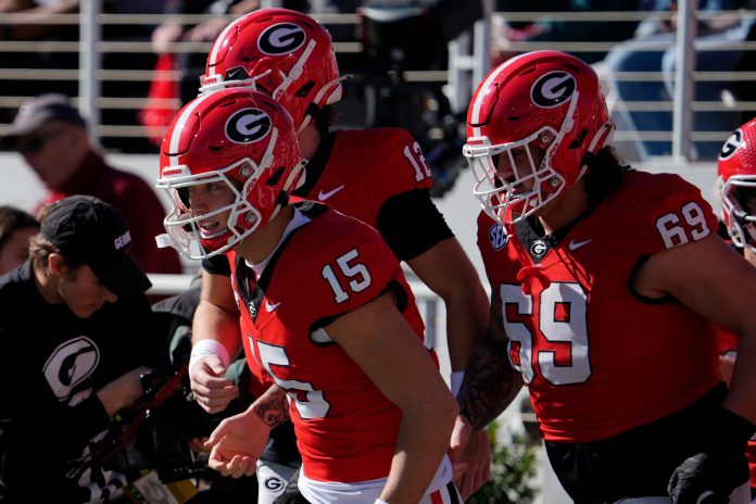 Georgia quarterback Carson Beck (15) takes the field to warm up before the start of a NCAA college football game against Massachusetts in Athens, Ga., on Saturday, Nov. 23, 2024.