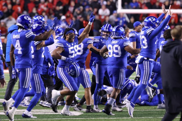 The Brigham Young Cougars run on the field after defeating the Utah Utes at Rice-Eccles Stadium.