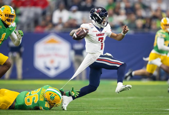 Liberty Flames quarterback Kaidon Salter (7) evades a tackle by Oregon Ducks linebacker Devon Jackson (26) during the second half in the 2024 Fiesta Bowl at State Farm Stadium.