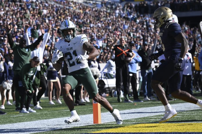 Tulane Green Wave running back Makhi Hughes (21) scores in front of Navy Midshipmen safety Kenneth McShan (0) during the second half at Navy-Marine Corps Memorial Stadium.