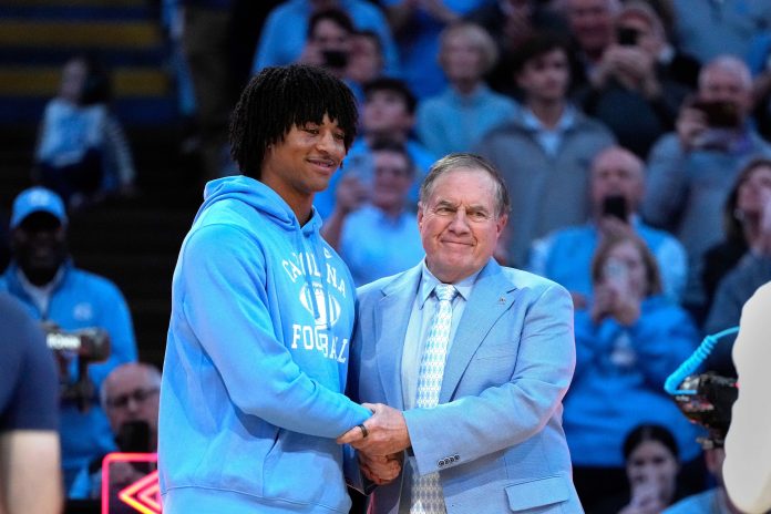 North Carolina Tar Heels head football coach Bill Belichick with recruit quarterback Bryce Young during half time at Dean E. Smith Center.