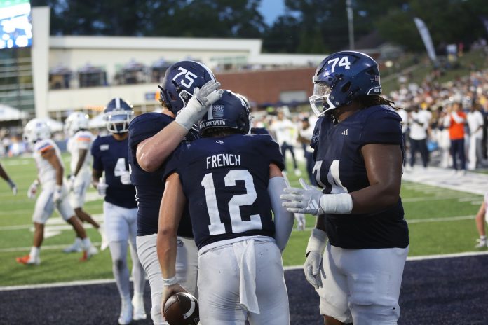 Georgia Southern Eagles quarterback JC French (12) celebrates with offensive lineman Bryson Broadway (75) and offensive lineman Pichon Wimbley (74) after converting a two point play against the Boise State Broncos at Paulson Stadium.