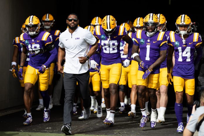 LSU Tigers wide receivers coach Cortez Hankton, tight end Ka'Morreun Pimpton (88), and wide receiver Aaron Anderson (1) run onto the field before the game against the Wisconsin Badgers at Raymond James Stadium.